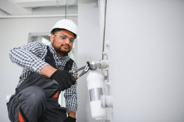 Su tesisatçısı takıyor - metre, filtre ve basınç azaltıcı.