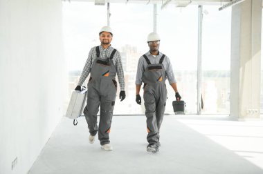 Çok ırklı bir grup inşaat inşaat işçisi iş yerinde toplanıyor..