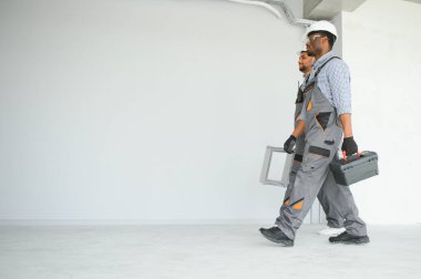 Çok ırklı bir grup inşaat inşaat işçisi iş yerinde toplanıyor..