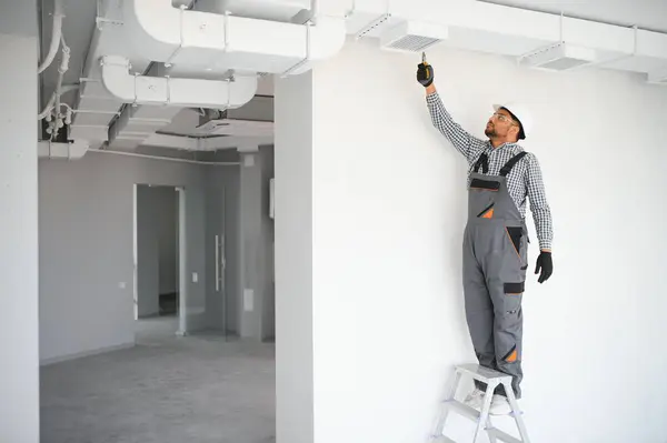 stock image hvac services indian worker install ducted pipe system for ventilation and air conditioning in house.