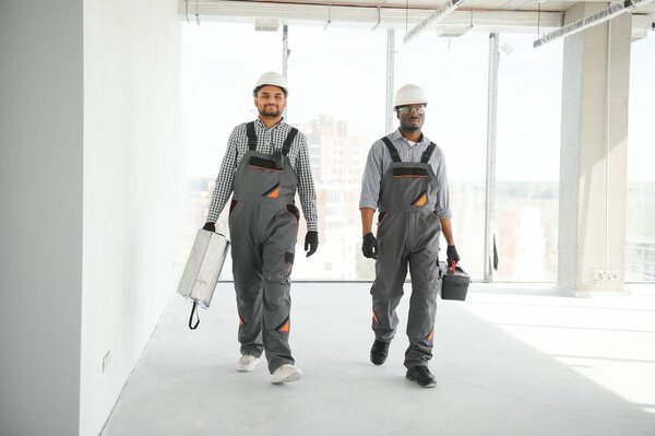Multicultural Builders Hardhats Construction Site Stock Photo
