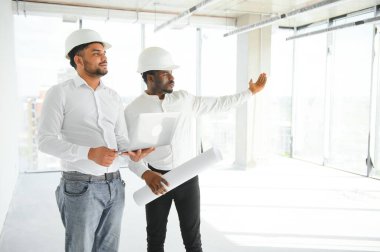 Çok ırklı bir grup inşaat inşaat işçisi iş yerinde toplanıyor..