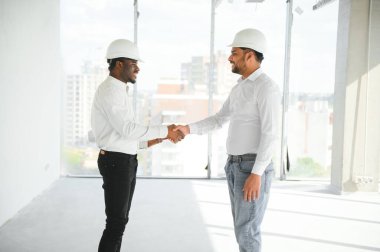 Çok ırklı bir grup inşaat inşaat işçisi iş yerinde toplanıyor..