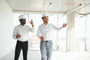 Çok ırklı bir grup inşaat inşaat işçisi iş yerinde toplanıyor..