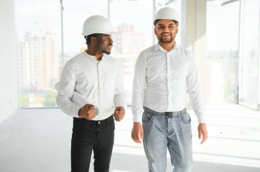 Çok ırklı bir grup inşaat inşaat işçisi iş yerinde toplanıyor..