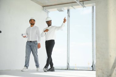 Çok ırklı bir grup inşaat inşaat işçisi iş yerinde toplanıyor..