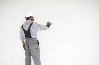 Üniformalı Afro-Amerikan Sıvacı, duvarları içeri yapıştırıyor..