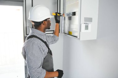 Bir erkek elektrikçi santralde çalışıyor..