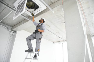 Profesyonel bir tamirci odaya klima kuruyor..