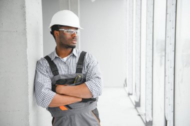 Afrikalı bir elektrikçi inşaat alanına elektrik prizleri kuruyor.