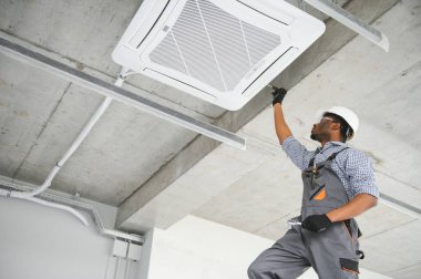 Profesyonel bir tamirci odaya klima kuruyor..