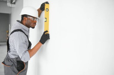 Gözlemleyerek ve su seviyesi kullanarak duvar hizalama etüt inşaat işçisi.