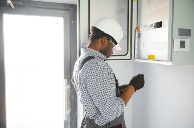 Bir erkek elektrikçi santralde çalışıyor..