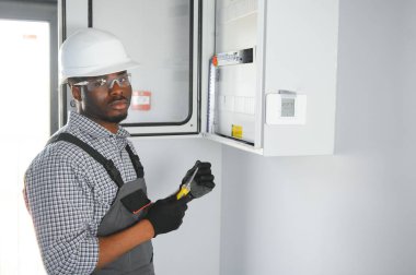 Bir erkek elektrikçi santralde çalışıyor..