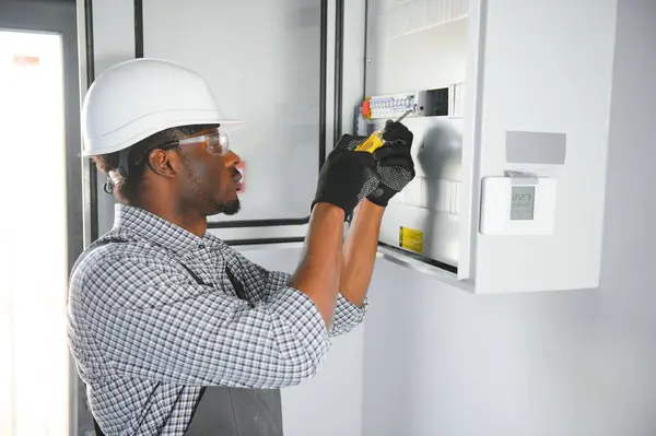 stock image A male electrician works in a switchboard.