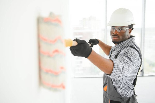 African Man Paints White Wall Roller Repair Interior Stock Image