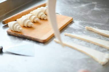 Fırını dükkanında klasik kruvasan üreten. Kadın içine daha fazla pişirme için rulo hamur yuvarlanıp gidiyor. Fransız malları.