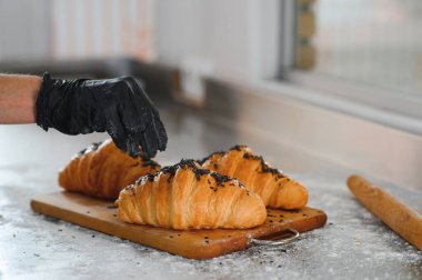 Fırıncı bitmiş kruvasanları süslüyor..