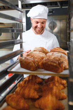 Erkek baker bir tepsi fırında ekmek fırını dükkanında holding.