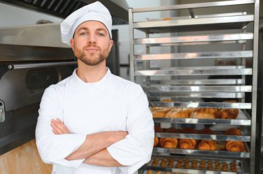 Mutlu fırıncı fırında ekmek ile tepsi nin yanında duran.