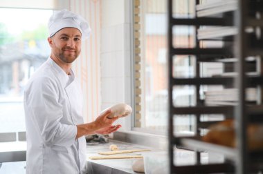 Mutlu fırıncı hamur yoğurur fırında.