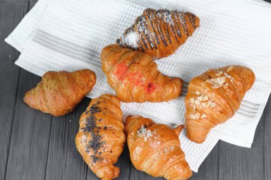 Lezzetli kruvasanlarla dolu bir masa, yakın plan. Fransız pastası..