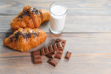Sütlü çikolata ve çikolatalı kruvasan ve bir bardak süt..