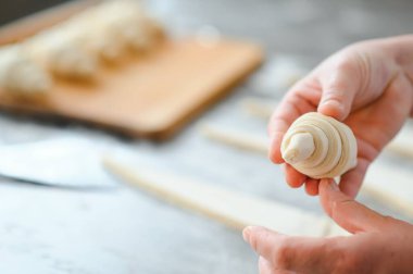 Fırını dükkanında klasik kruvasan üreten. Kadın içine daha fazla pişirme için rulo hamur yuvarlanıp gidiyor. Fransız malları.