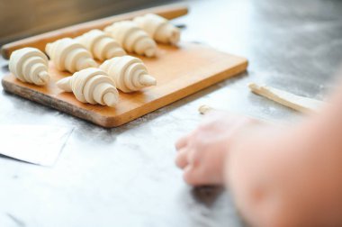 Fırını dükkanında klasik kruvasan üreten. Kadın içine daha fazla pişirme için rulo hamur yuvarlanıp gidiyor. Fransız malları.