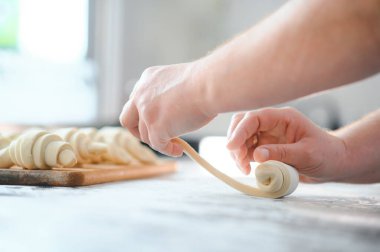 Fırını dükkanında klasik kruvasan üreten. Kadın içine daha fazla pişirme için rulo hamur yuvarlanıp gidiyor. Fransız malları.