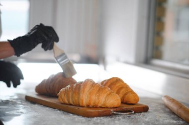 Fırıncı bitmiş kruvasanları süslüyor..