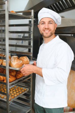 Mutlu fırıncı fırında ekmek ile tepsi nin yanında duran.