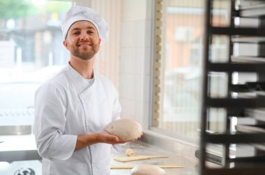 Mutlu fırıncı hamur yoğurur fırında.