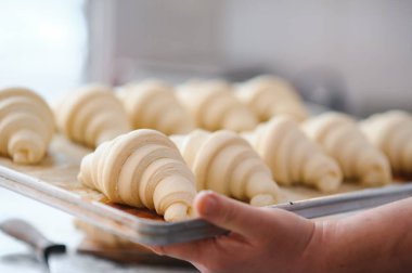 Fırını dükkanında klasik kruvasan üreten. Kadın içine daha fazla pişirme için rulo hamur yuvarlanıp gidiyor. Fransız malları.