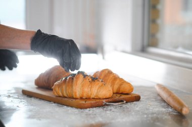 Fırıncı bitmiş kruvasanları süslüyor..