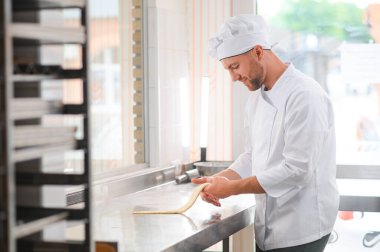 Mutlu fırıncı hamur yoğurur fırında.