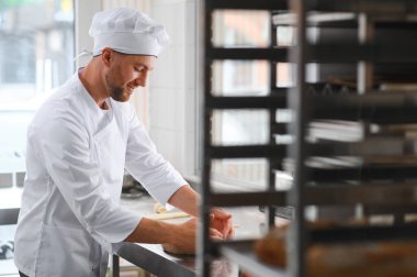 Mutlu fırıncı hamur yoğurur fırında.