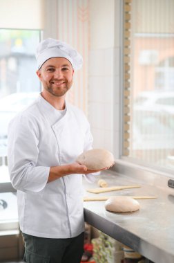 Mutlu fırıncı hamur yoğurur fırında.