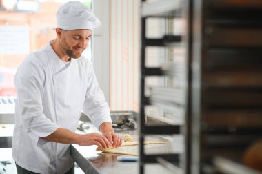 Pasta şefi fırında kruvasan yapıyor..