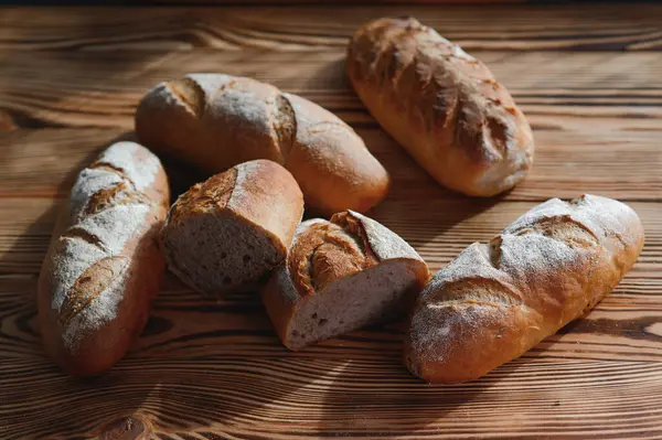 Fırın raflarında taze pişmiş ekmek. Parlak ışıkta ekmek çeşitliliği. Tahta raflarda altın hamurlu ekmek. Ekmek çeşitleri..