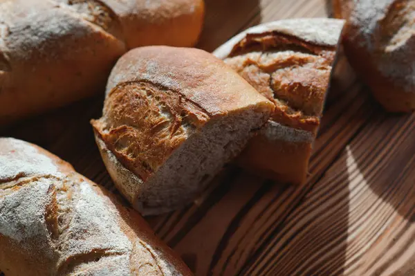 Yuvarlak ekmek yakın plan. Fırın raflarında altın hamurlu taze ekşi ekmek. Lezzetli ekmekle birlikte fırın içeriği. Hamur işleri.