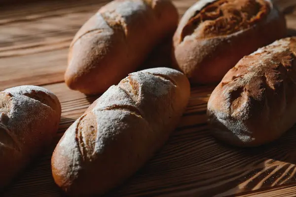 stock image Round bread close-up. Freshly baked sourdough bread with a golden crust on bakery shelves. Baker shop context with delicious bread. Pastry items.