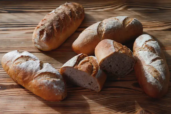 stock image Round bread close-up. Freshly baked sourdough bread with a golden crust on bakery shelves. Baker shop context with delicious bread. Pastry items.