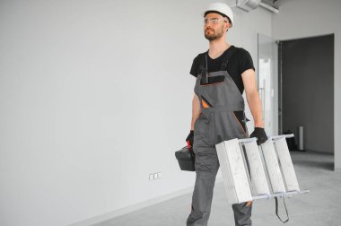 İnşaat alanında kaskı olan sevimli beyaz sakallı inşaat işçisi..