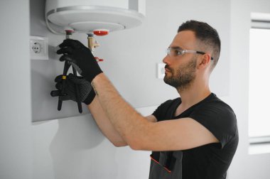 Profesyonel tesisatçı kazan ve boruları kontrol ediyor..