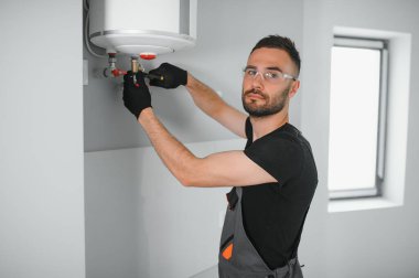 Profesyonel tesisatçı kazan ve boruları kontrol ediyor..