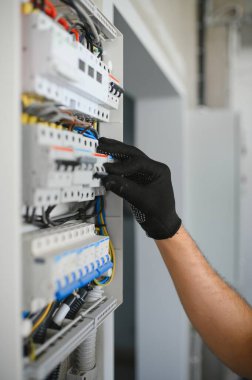 Bir erkek elektrikçi santralde çalışıyor..