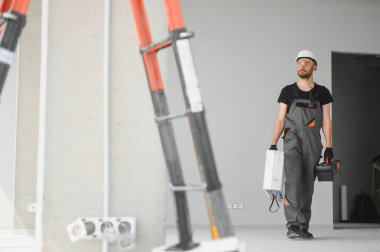 İnşaat alanında kaskı olan sevimli beyaz sakallı inşaat işçisi..