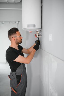 Profesyonel tesisatçı kazan dairesinde çalışıyor..