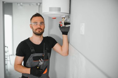 Profesyonel tesisatçı kazan ve boruları kontrol ediyor..